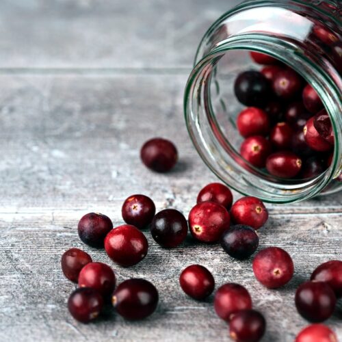 red round fruits in clear glass jar