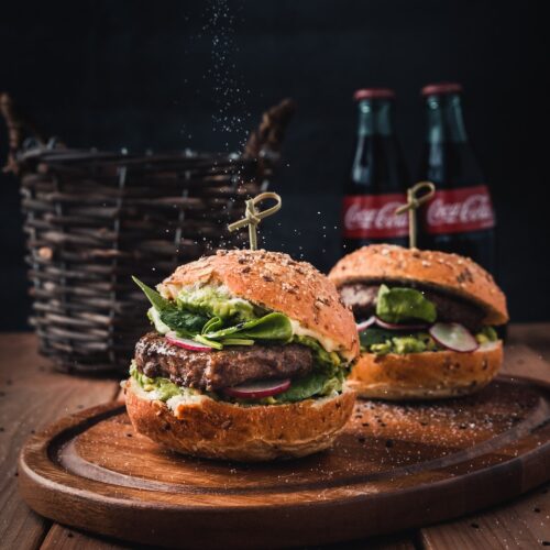 burger with vegetable on brown wooden tray