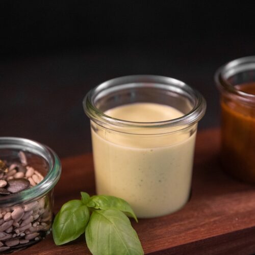 a wooden cutting board topped with jars filled with food