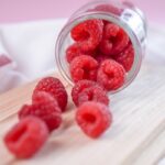 red raspberry on clear glass jar