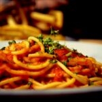 a plate of spaghetti with tomato sauce and parsley